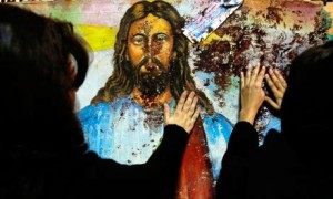 Jesus painting splattered with the blood of Christian worshipers killed during the 2011 bombing of the Church of Two Saints.