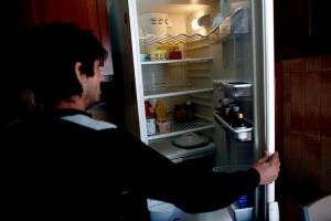 Michalis Petrakis, who is jobless and whose son Pantelis has been going to school hungry, shows his nearly empty refrigerator.