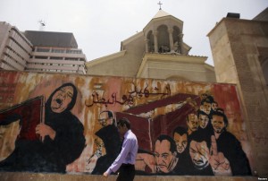 A man walks past graffiti depicting a funeral outside a church near Cairo's Tahrir Square on Thursday. The graffiti reads "Martyr or hero". Photo: CNS/Amr Abdallah Dalsh, Reuters