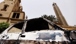 A car burnt in clashes between Muslims and Coptic Christians in April lies in front of Cairo's main Coptic Cathedral. Photo by Reuters