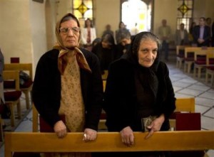 In this photograph made on Sunday, Oct. 27, 2013, women stand during a service in an Armenian Orthodox church in Damascus, Syria. Attacks on Christian districts of the capitals and on Christian villages elsewhere have fueled fears among Syria's religious minorities about the growing role of Islamic extremists among the armed rebels fighting against President Bashar Assad's rule. ((AP Photo/Dusan Vranic))