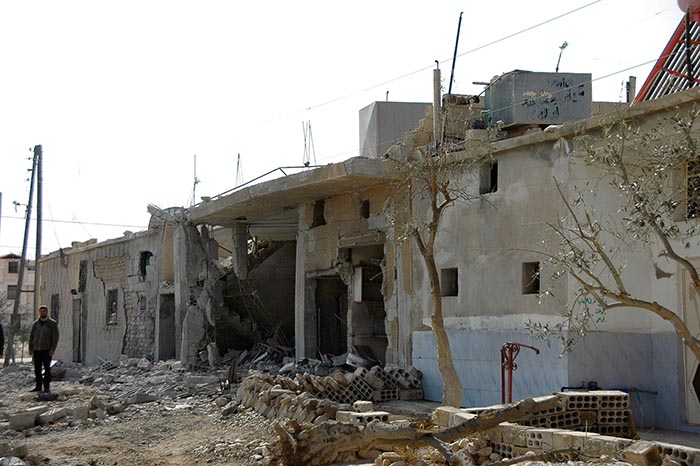 Aftermath: a man stands next to ruined homes in Sadad after government forces took control of it from rebel fighters.