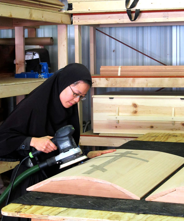 Getting buff: Mother Paraskeva puts a finish on a handmade casket, one of several fundraising items produced by the monastery. (Judith van Vliet)