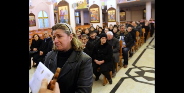Syrian people from the Christian town of Maalula, a symbol of the ancient Christian presence in Syria which is currently under control of Syrian rebels, including jihadist groups, attend a mass service at the Saint Joseph church on December 18, 2013 in Damascus. Syrian Melkite Greek Catholic Patriarch Gregory III Laham, has called on his fellow Christians to stay in Syria, despite the brutal conflict raging in the country. According to the patriarch, 450,000 Syrian Christians have been displaced by the conflict that began in March 2011, around 40,000 of whom have fled to Lebanon. AFP PHOTO/LOUAI BESHARA