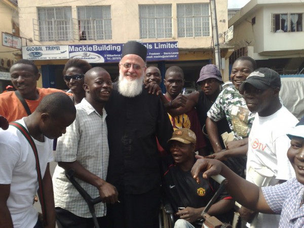 Despite the Danger, Courageous Former Rock Star Turned Missionary, Fr. Themi Adams, Has Decided to Stay Put with His Flock in Sierra Leone