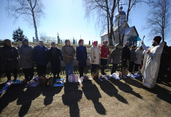 An Orthodox priest blesses cakes and colored eggs during an Orthodox Easter ceremony in the village of Zaskovichi, some 95 kms northwest of Minsk. April 11, 2015. 