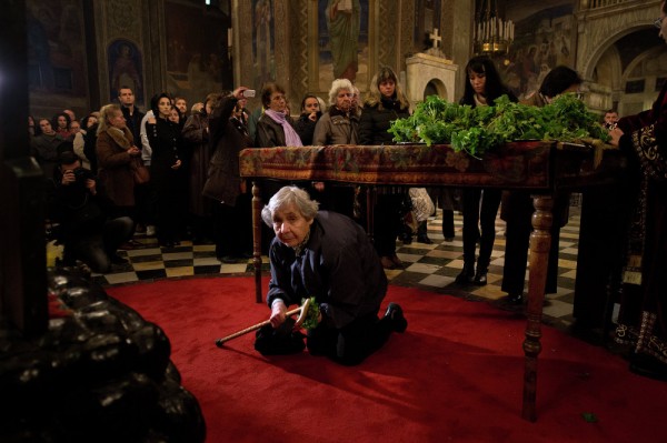 A Christian passes under a table on which a Bible is placed during the Good Friday service in the eastern-orthodox golden-domed Alexander Nevski cathedral in Sofia. April 10, 2015.