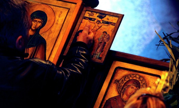 A man touches an icon with the crucifixion of Jesus Christ on Good Friday at St. Petka Orthodox church in Skopje, Macedonia. April 10, 2015.