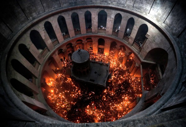 Worshipers hold up candles lit from the "Holy Fire" as thousands gather in the Church of the Holy Sepulchre in Jerusalem’s Old City. April 11, 2015. 