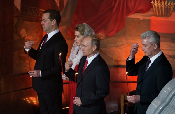 Russian President Vladimir Putin (C), Prime Minister Dmitry Medvedev (L), his wife Svetlana (second from the left), and Mayor Sergei Sobyanin (R) cross themselves during the Easter service in Christ the Savior Cathedral in Moscow, Russia. April 12, 2015.