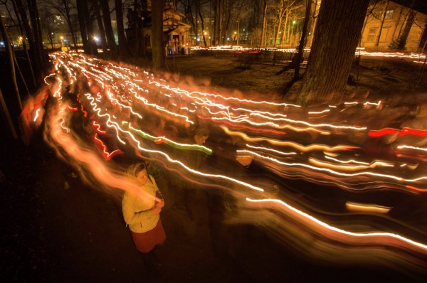 In this photo taken with long time exposure, Orthodox believers walk with candles during Easter midnight mass at a church in St. Petersburg, Russia. April 12, 2015.