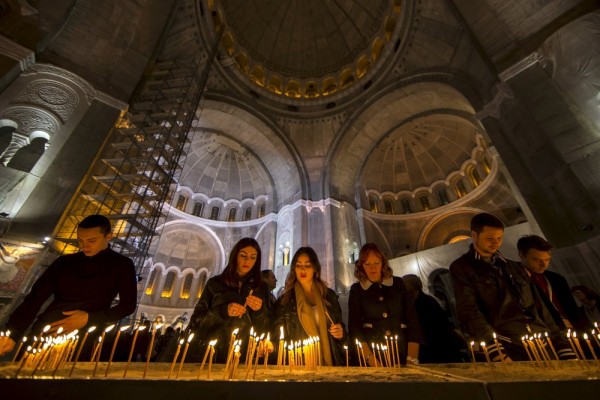 Worshippers light candles in the St. Sava temple during an Orthodox Easter service in Belgrade. April 11, 2015.