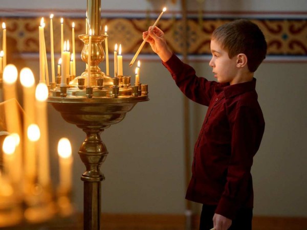 A young boy lights a candle for the living and the dead as a means of paying homage to both at the front of the church upon entering. Christ the Saviour Orthodox Church held their Christmas service. JULIE OLIVER / OTTAWA CITIZEN