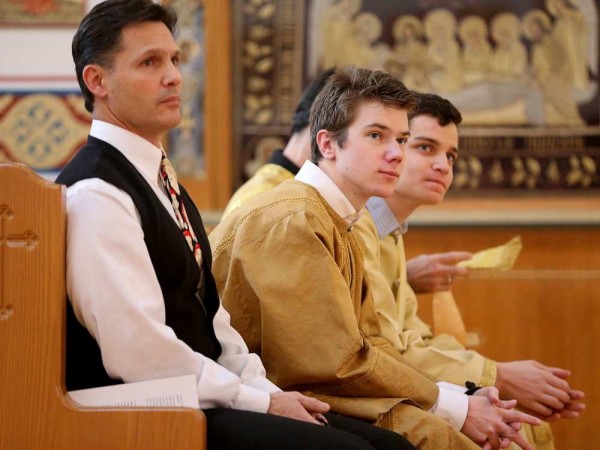 Altar boy Nicholas La Libertie (centre) sits with other church members at the front while listening to the service. JULIE OLIVER / OTTAWA CITIZEN