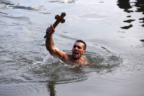 Nikolas Solis, 28, holds a wooden crucifix after retrieving it from the Golden Horn in Istanbul Murad Sezer/Reuters