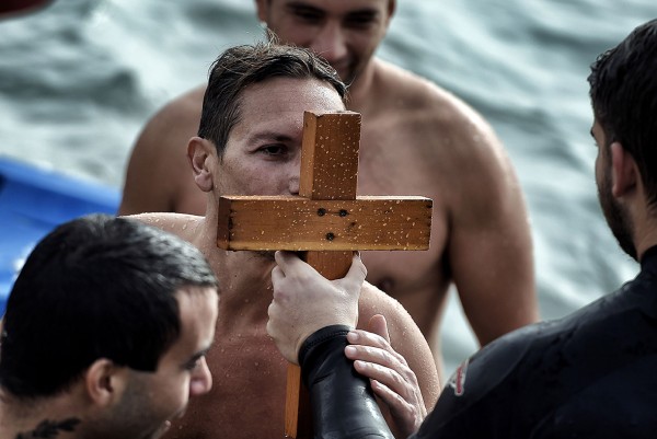 A swimmer kisses a wooden cross after retrieving it from the sea on Epiphany Day in a southern suburb of Athens, Greece Aris Messinis/AFP