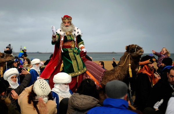 A man dressed as one of the Three Wise Men greets children upon arriving at Poniente beach in Gijon, Spain Eloy Alonso/Reuters