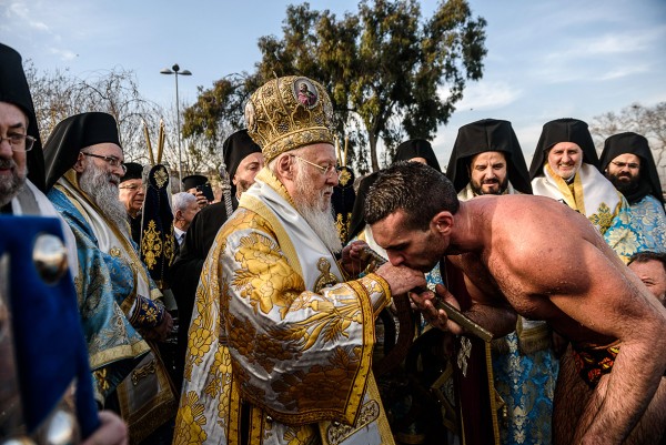 Nicolaos Solis kisses the hand of Greek Orthodox Ecumenical Patriarch Bartholomew near the Bosphorus river's Golden Horn in Istanbul Ozan Kose/AFP