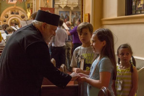 Bishop Paul meeting with some of the children attending St. Mary’s vacation bible school who sang with symposium participants