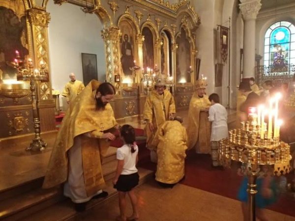 Archimandrite Sergius holds cross for veneration at the end of the Liturgy.