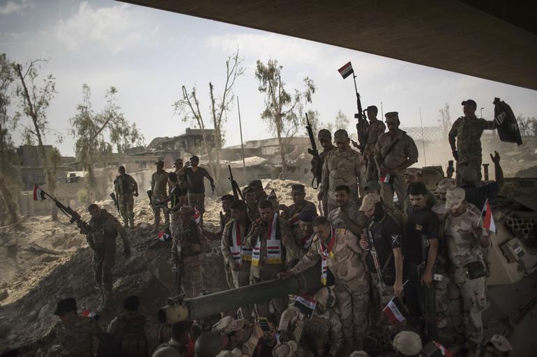 Iraqi Army soldiers gather to celebrate their gains as their fight against Islamic State militants continues in the Old City of Mosul, Iraq, Sunday, July 9, 2017. (AP Photo/Felipe Dana)