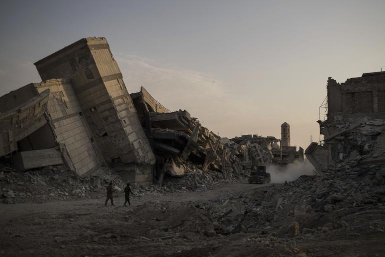 Iraqi soldiers walk in a damaged street as Iraqi forces continue their fight against Islamic State militants in parts of the Old City of Mosul, Iraq, Sunday, July 9, 2017. (AP Photo/Felipe Dana)