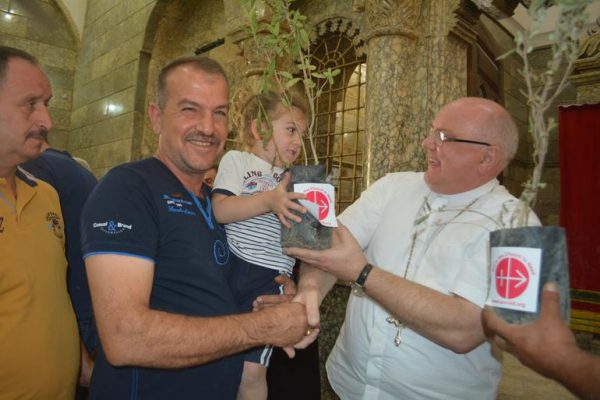 Aid to the Church in Need Middle East projects’ coordinator Father Andrzej Halemba distributes olive tree to a Christian family at St George’s Church, Bartela