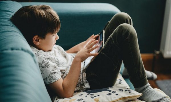 “He Is Lying on the Couch Lost in His Phone”